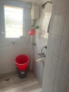 a bathroom with a red bucket in a shower at Boho connection in Mumbai