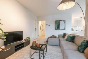 a living room with a couch and a flat screen tv at Huswell - Beautiful apartment with terrace and parking in Ostend