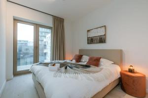 a bedroom with a large bed and a large window at Huswell - Beautiful apartment with terrace and parking in Ostend
