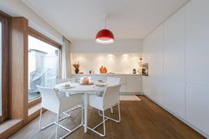 cocina y comedor con mesa blanca y sillas en Modern renovated apartment with terrace and parking, en Knokke-Heist