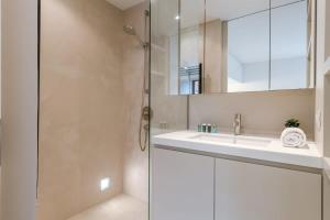 uma casa de banho com um lavatório e um chuveiro em Modern renovated apartment with terrace and parking em Knokke-Heist
