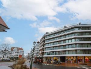 un gran edificio en una calle de la ciudad con edificios en Modern renovated apartment with terrace and parking, en Knokke-Heist