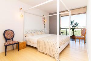 um quarto com uma cama de dossel branca e duas cadeiras em Apartment Terracota By Dalma Portuguesa na Galé