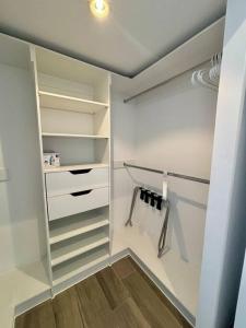 a walk in closet with white cabinets and shelves at Apartment with perfect city view in Guatemala