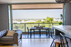 uma sala de estar com uma mesa e cadeiras e uma grande janela em Apartment Terracota By Dalma Portuguesa na Galé