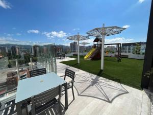 a balcony with a table and chairs and a playground at Apartment with perfect city view in Guatemala