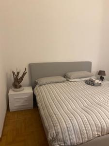 a bedroom with a bed with a gray headboard and a night stand at La bella vista in Sestri Levante