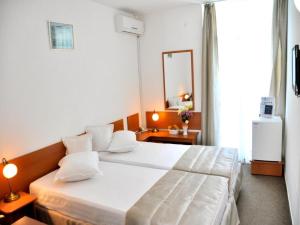 a bedroom with a large white bed with a mirror at Hotel Decebal Estival Neptun in Neptun +37 photos