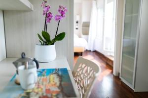a table with a vase with purple flowers on it at Rex Hotel Residence in Genoa