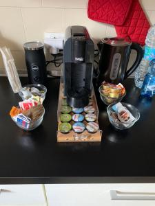 ピサにあるPisa City Home B&Bのコーヒーメーカー付きの黒いカウンターと食べ物のボウル