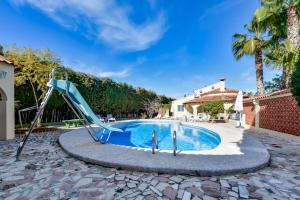 a pool with a slide next to a house at Villas Guzman - Xenia in Calpe