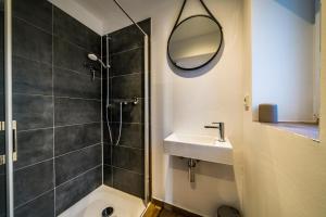 uma casa de banho com um chuveiro, um lavatório e um espelho. em RIAS-Beachvilla-Ocean em Borkum