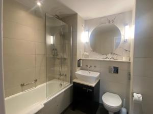 a bathroom with a sink and a toilet and a mirror at London Chigwell Prince Regent Hotel, BW Signature Collection in London