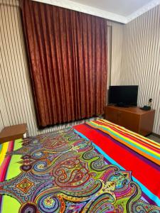 a bedroom with a large bed with a colorful blanket at Rezidens CASPIAN LINE in Buzovna