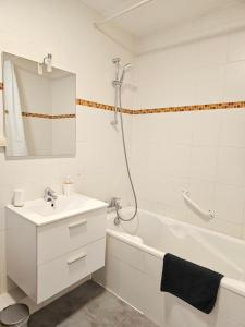 uma casa de banho branca com um lavatório e uma banheira em Appartement Cocooning em Roeschwoog
