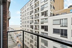 Apartment mit Balkon und Blick auf ein Gebäude in der Unterkunft Fully equipped apartment with lateral sea view in Blankenberge