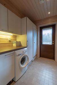 lavadero con lavadora y ventana en Villa Luoteistuuli - 8+2 hlö, Luoteis-Himos Ski-in/out, 88m² + 30m², en Jämsä