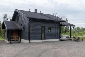 un edificio negro con una mesa de picnic delante en Villa Luoteistuuli - 8+2 hlö, Luoteis-Himos Ski-in/out, 88m² + 30m², en Jämsä