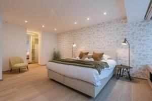 1 dormitorio con 1 cama grande y 1 silla en Spacious apartment with parking on prime location, en Knokke-Heist