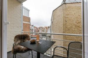 balcón con mesa y sillas en Spacious apartment with parking on prime location, en Knokke-Heist