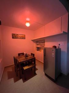a kitchen with a table and a refrigerator at GOKARNA JUNCTION - A vintage homestay in Gokarna