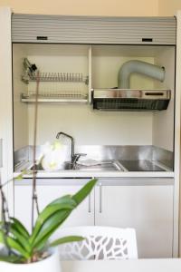 uma cozinha com um lavatório e um fogão em Rex Hotel Residence em Gênova