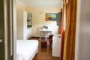 a small room with a bed and a table at Rex Hotel Residence in Genoa