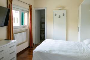 a bedroom with a white bed and a television at Rex Hotel Residence in Genoa