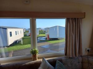 a living room window with a view of a house at SANDY BAY STAYOVER in North Seaton