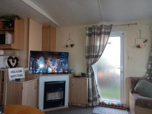 a living room with a tv and a fireplace at SANDY BAY STAYOVER in North Seaton