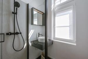 イーペルにあるHuswell - Pleasant apartment in the center of Ypresの洗面台と鏡付きのシャワーを備えたバスルーム