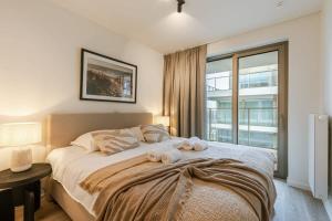 een slaapkamer met een groot bed en handdoeken bij Beautiful apartment overlooking the marina in Oostende