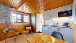 a kitchen with a table and some chairs in a room at Charming alpine studio in the Val d'Anniviers in Saint-Luc