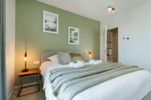 1 dormitorio con 1 cama blanca grande y 2 almohadas en Apartment with beautiful seaview in Ostend, en Ostende