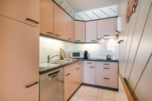 a kitchen with white cabinets and a sink at Huswell - Beachfront apartment in Zeebrugge in Bruges