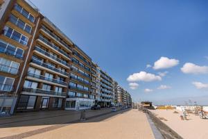 a large building on the beach next to the beach at Beachfront apartment in Zeebrugge in Bruges