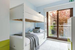 a white bunk bed in a room with a window at Beachfront apartment in Zeebrugge in Bruges