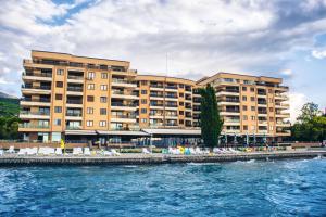 a large building next to a body of water at Park Lakeside Ohrid in Ohrid