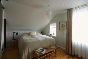 Un dormitorio con una cama grande y una ventana en Hótel Karólína, en Stykkishólmur