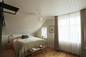 1 dormitorio con cama y ventana grande en Hótel Karólína, en Stykkishólmur