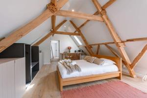 a bedroom with a bed in a loft with wooden beams at Charming room in the green neighbourhood of Gent in Ghent