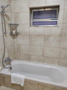a bathroom with a bath tub and a window at CMK Housing in Madaba