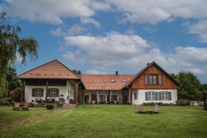 a house with a green yard with chairs on it at Őri Art Inn in Őriszentpéter