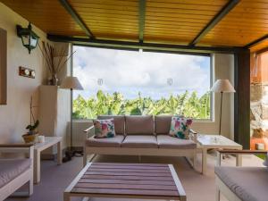 a living room with a couch and a large window at Modern Banana Plantation House with sea views and private pool in Arucas