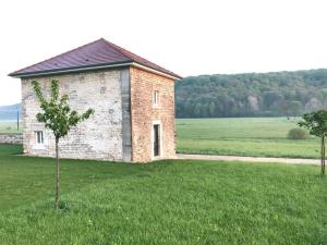 a brick building in the middle of a field at Les Gîtes de la Vallée de l'aujon (10 pers) in Arc-en-Barrois