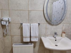 a bathroom with a sink and a mirror and towels at CMK Housing in Madaba