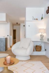 Sala de estar blanca con silla blanca y mesa en High-end apartment in centre of Knokke with parking, en Knokke-Heist