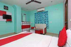 a bedroom with a bed and a desk with a chair at OYO Hotel Maruti Lodging in Dum Dum
