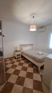 1 dormitorio con 1 cama y suelo a cuadros en MS4 Apartamentos Nervión, en Sevilla