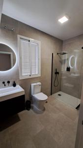 y baño con aseo, lavabo y ducha. en MS4 Apartamentos Nervión, en Sevilla